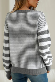 Gray and white striped knit sweater with crew neck and long sleeves.