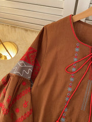 Brown folk-inspired tie neck shirt with red and grey embroidery on sleeves and neckline.