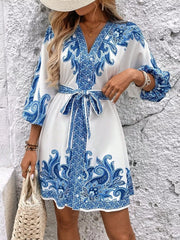 Blue paisley print mini dress with V-neck, billowy sleeves, and waist tie
