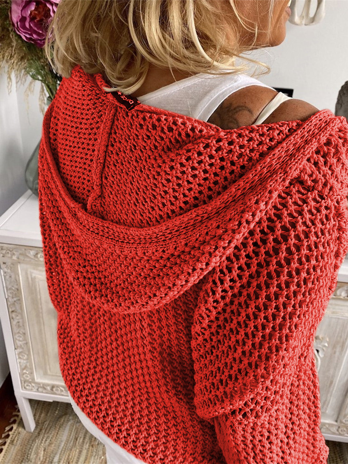 Red open-knit slouchy hooded sweater with a relaxed fit and crochet detail.