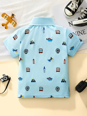 Light blue toddler polo shirt with cartoon cars, dinosaurs, and London landmarks print.