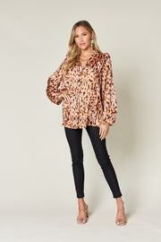 Caramel print ruffle front blouse with balloon sleeves and buttoned V-neck.