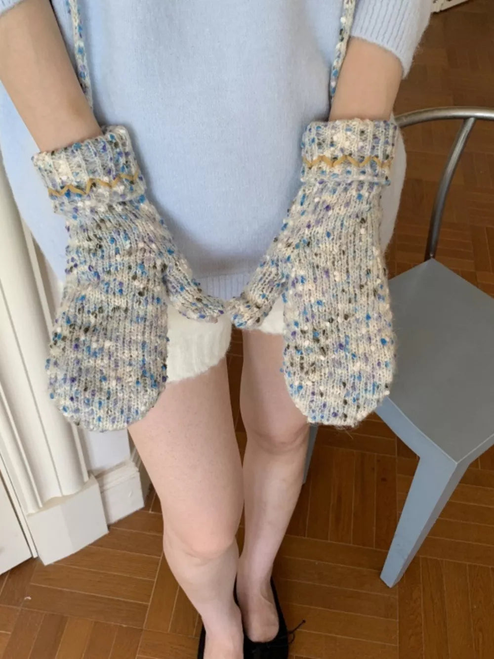Textured knit mittens in light blue with zig-zag detail and flecks of purple and brown