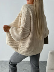 Beige textured knit cardigan with puff sleeves and ribbed details.