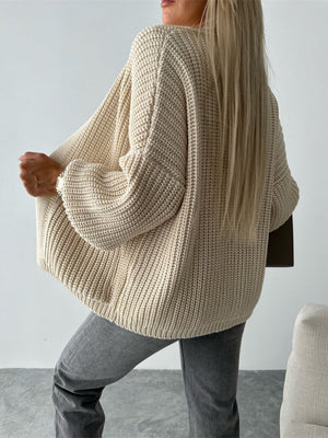 Beige textured knit cardigan with puff sleeves and ribbed details.