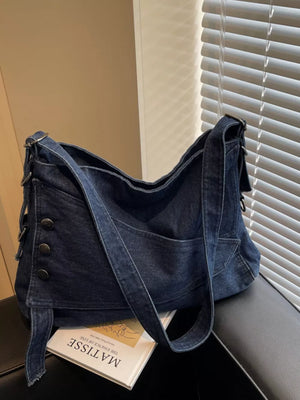 Relaxed denim crossbody bag with button accents and adjustable strap.