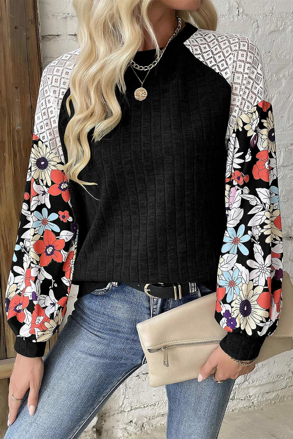 Black blouse with floral print sleeves and white lace shoulder detail