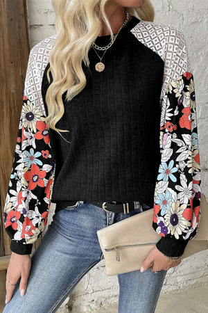 Black blouse with floral print sleeves and white lace shoulder detail