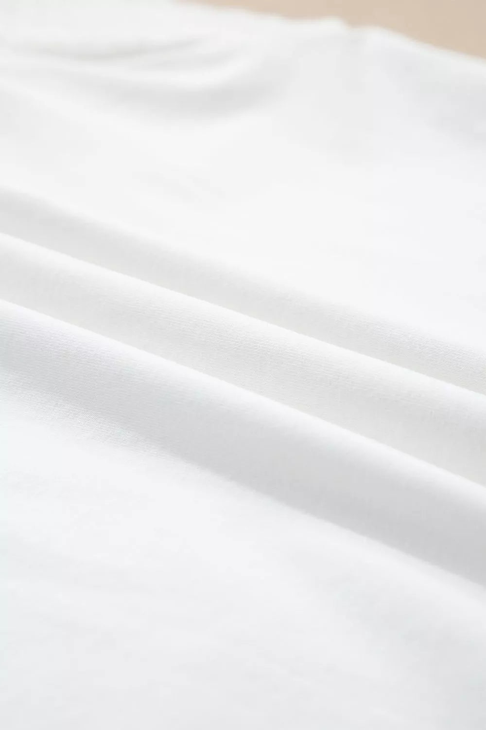White cotton maternity t-shirt with delicate eyelet detail and flutter sleeves.