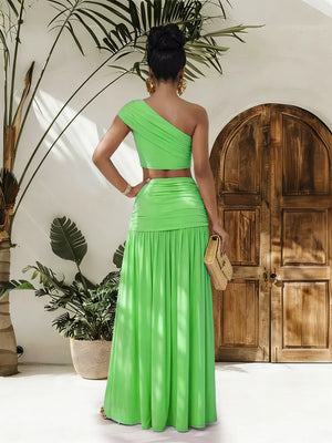 One-shoulder ruched crop top and maxi skirt set in bright green, featuring a cutout detail.