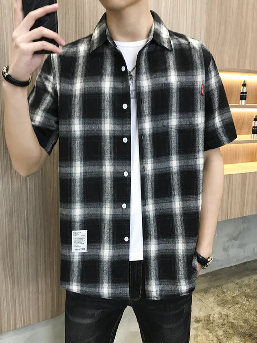 Black and white plaid oversized short sleeve button-down shirt with white t-shirt underneath.