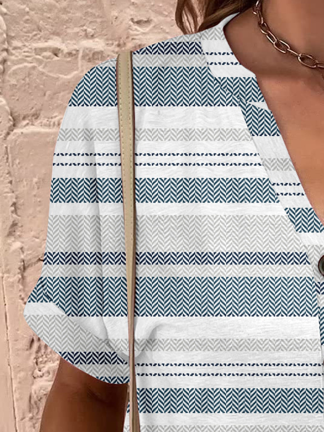Bohemian tapestry blouse with blue and gray stripes, short sleeves, and a V-neck with button detail.