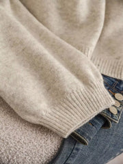 Apricot V-neck cardigan with balloon sleeves and bow detail, styled with jeans.