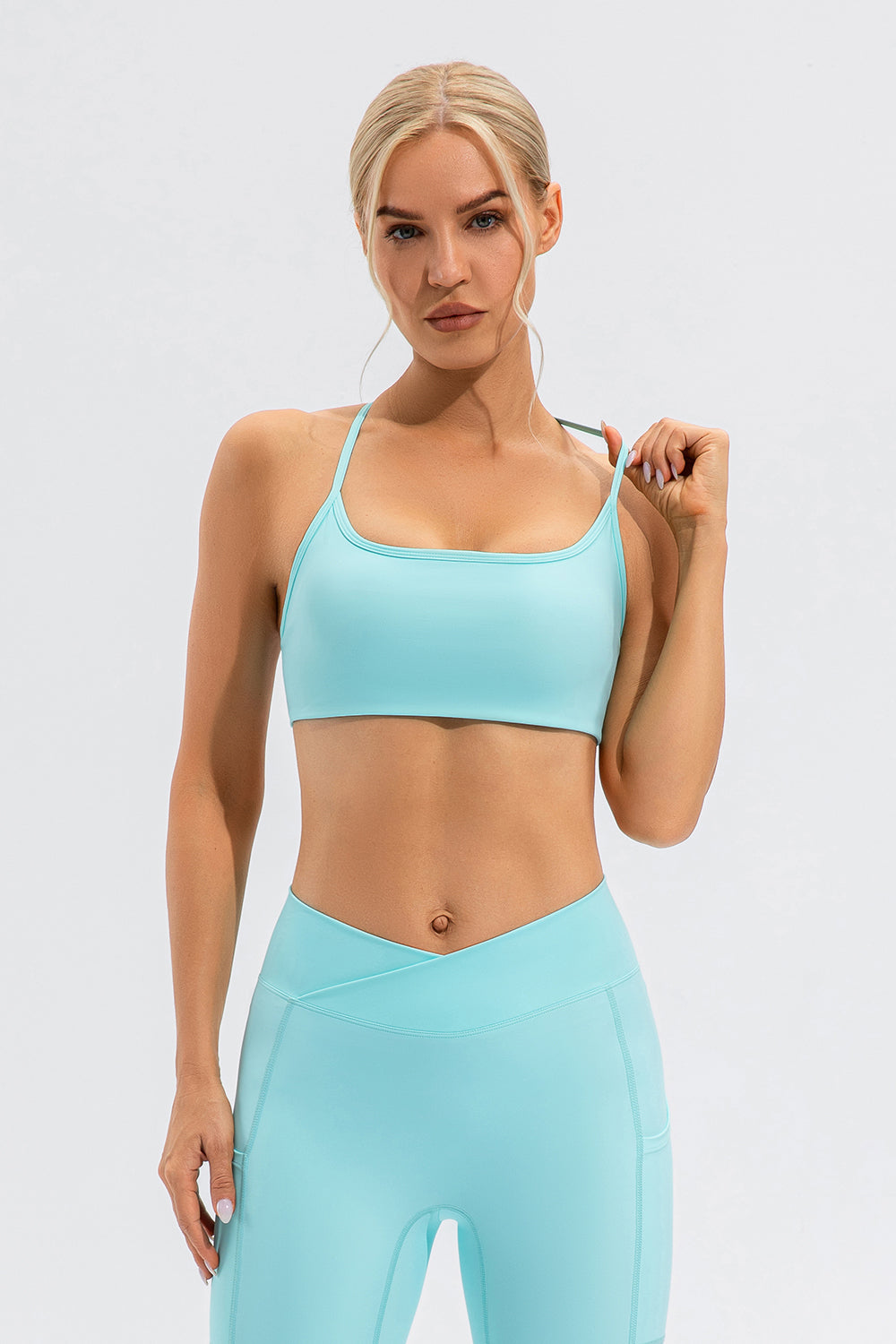 Aqua sports bra with thin straps and square neckline, paired with matching leggings.