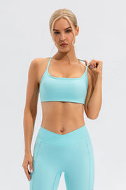 Aqua sports bra with thin straps and square neckline, paired with matching leggings.