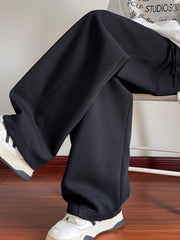 Men's black drawstring wide-leg sweatpants with a relaxed fit.
