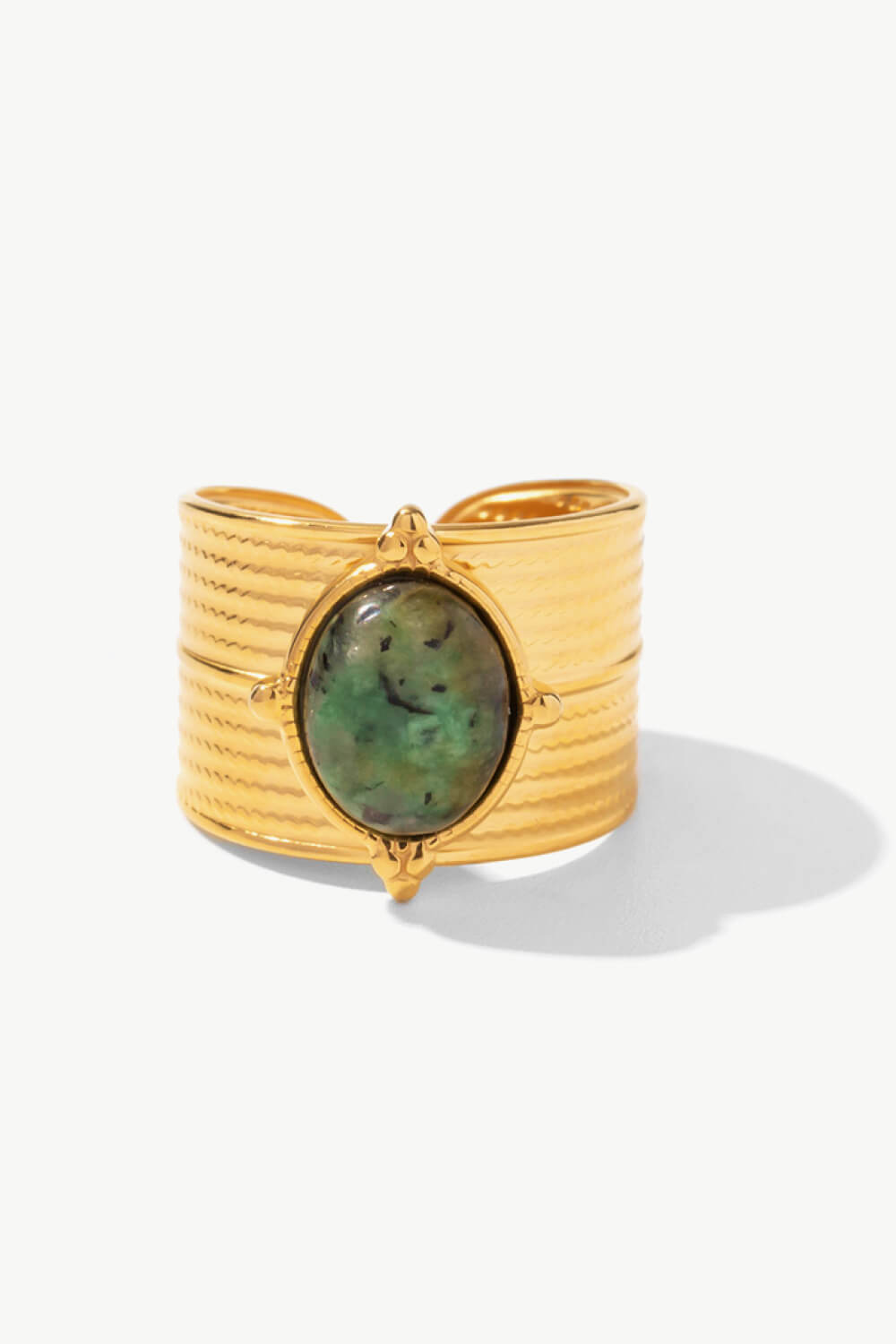 Textured gold cuff ring with a green tiger's eye stone and boho design.