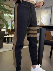 Men's black cotton sweatpants with caramel side stripes and drawstring waist.