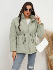 Light green textured puffer jacket with drawstring waist and zip-up front.