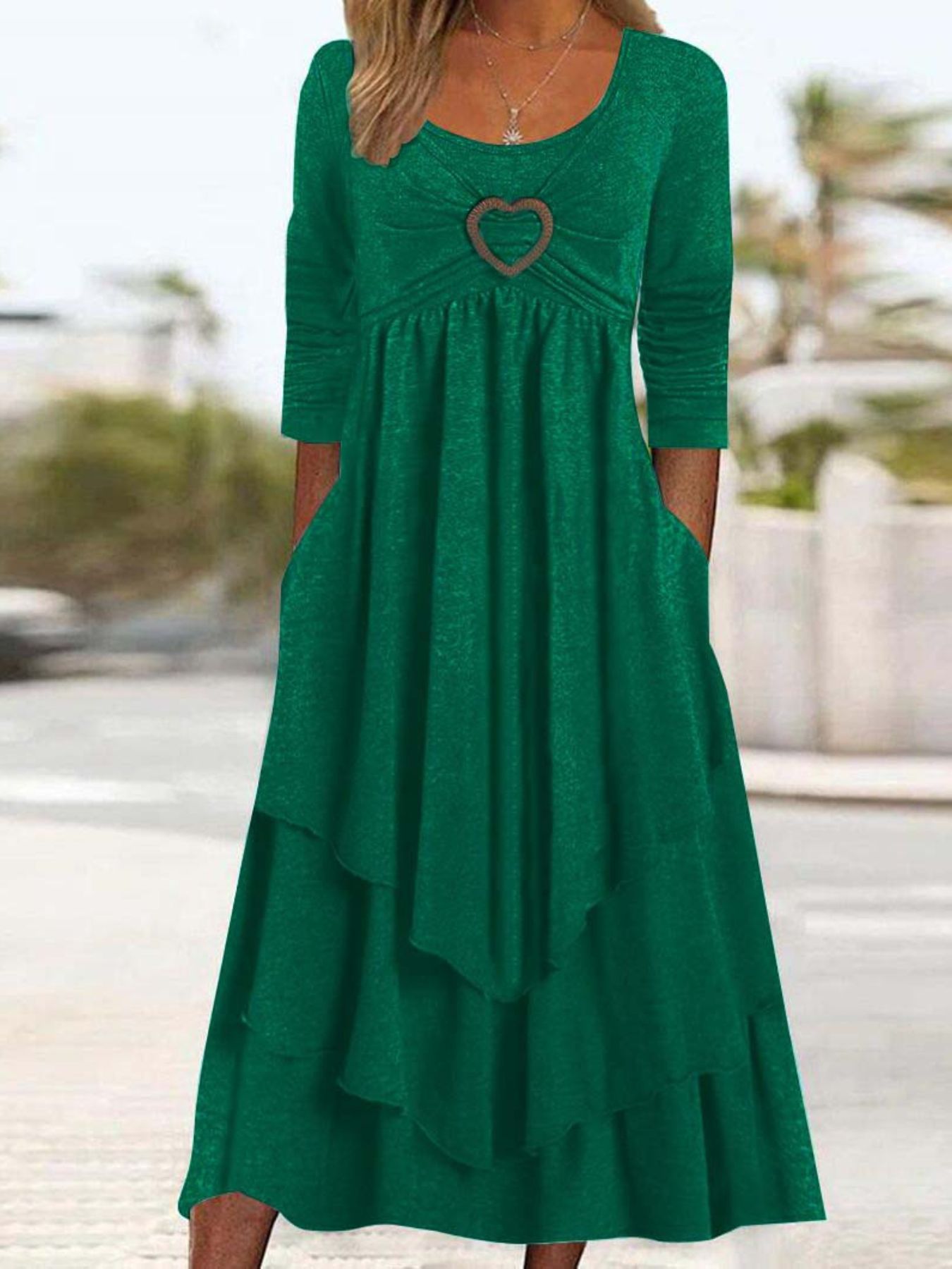 Green midi dress with heart detail, tiered skirt, and pockets.