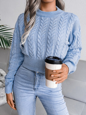 Light blue acrylic cable knit cropped mock neck sweater with a textured pattern.