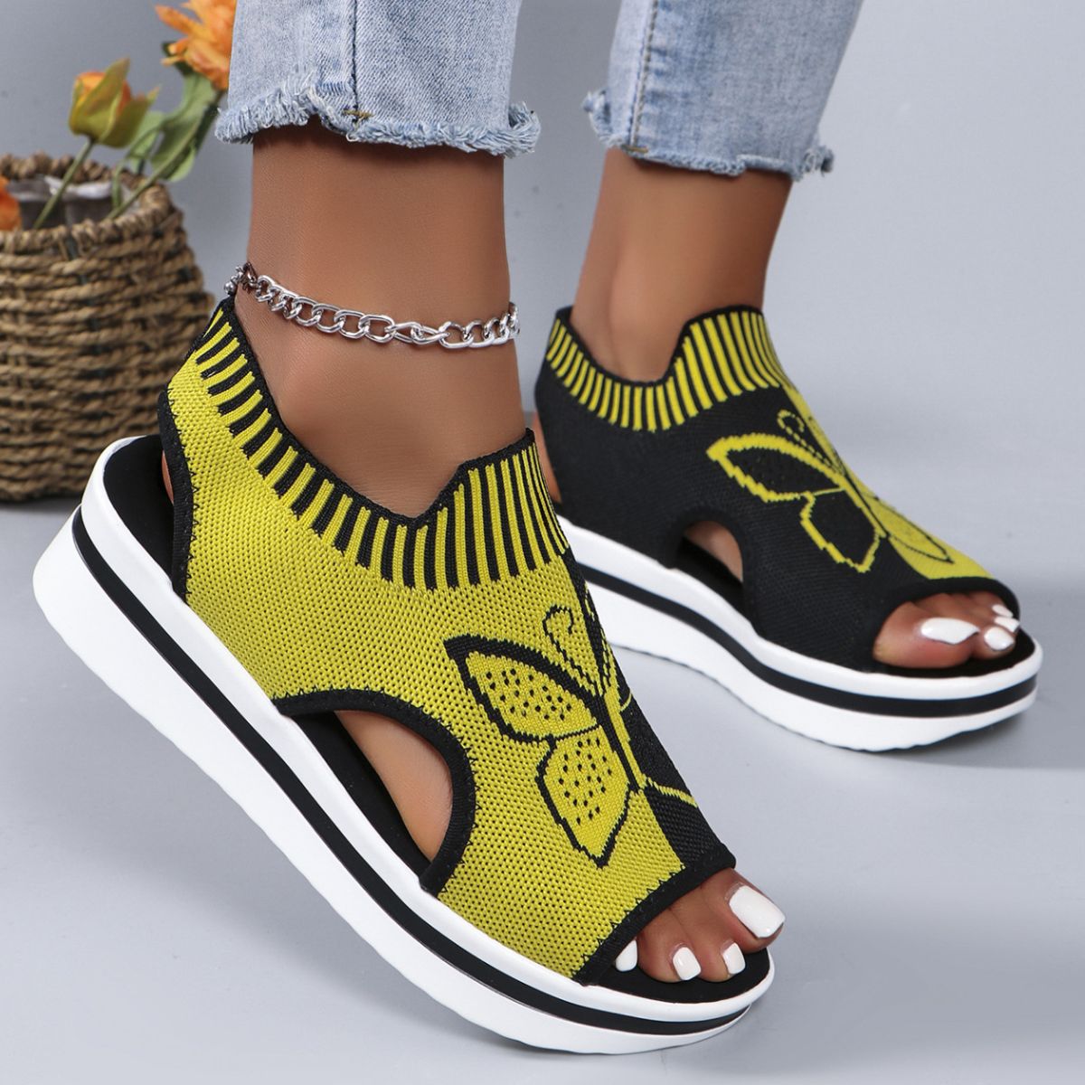 Yellow and black open-toe wedge sandals with butterfly motif and mesh detail