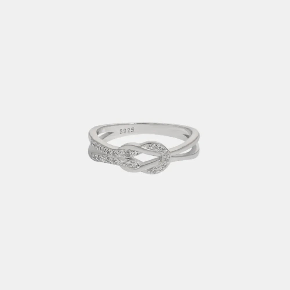 Silver knot ring with zirconia accents on a sterling silver band.