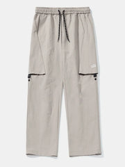 Gray cargo pants with drawstring waist and black trim pockets.