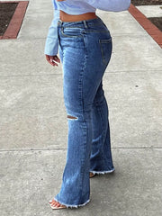 Distressed flare jeans in dark blue denim with a raw hem and knee rip.