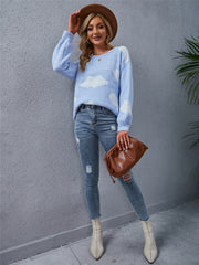 Light blue acrylic sweater with white cloud intarsia pattern, crew neck, and long sleeves.