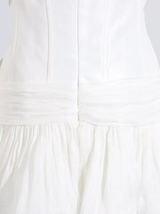 White mini dress with ruched bodice and tiered ruffled skirt.