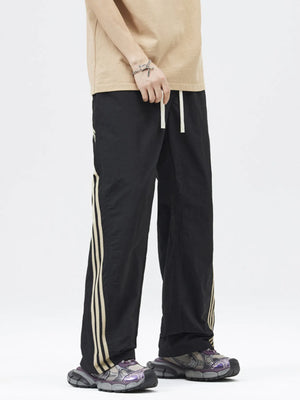 Black drawstring cargo pants with triple stripe detail on leg