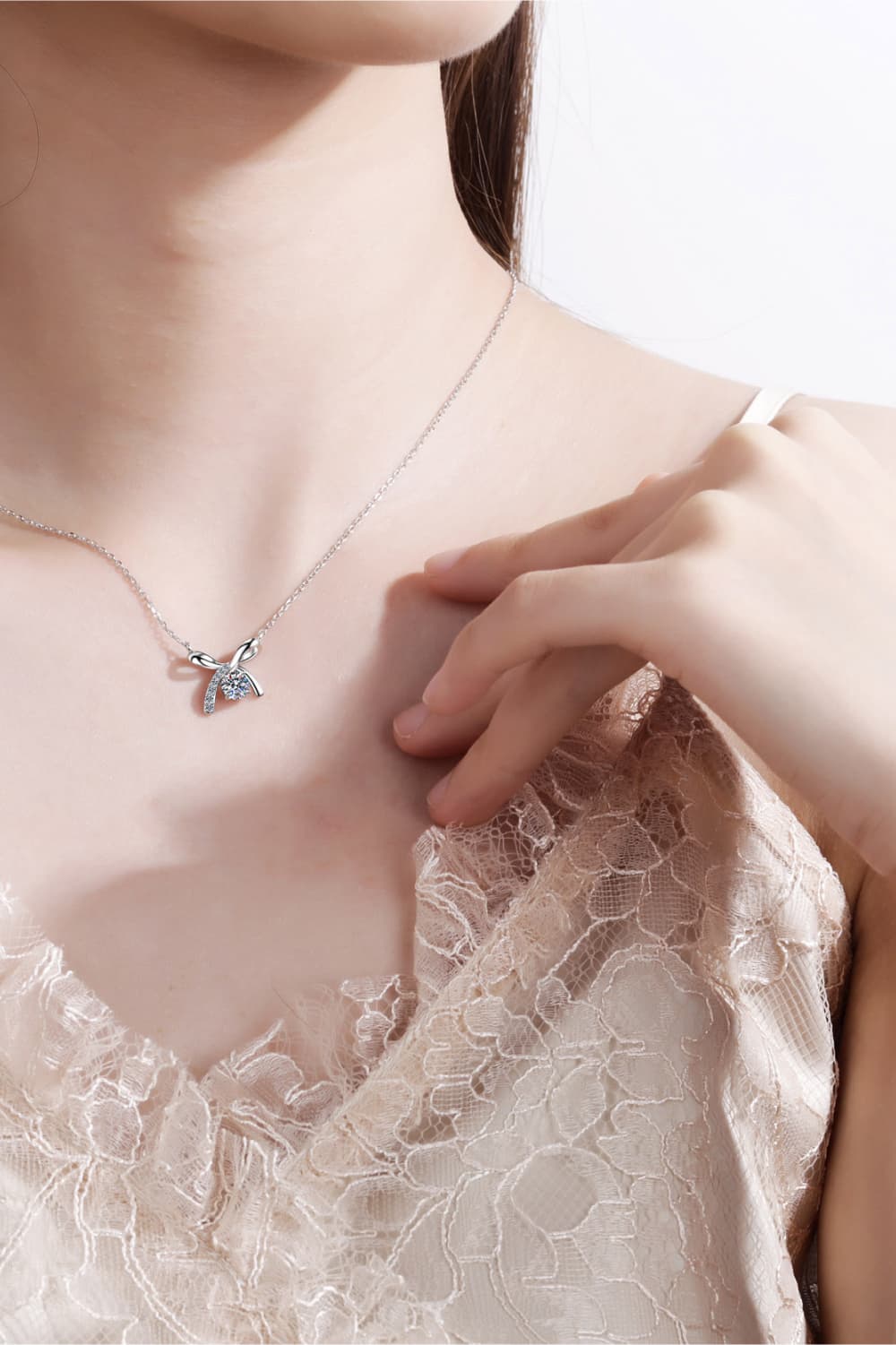 Silver bow-tie diamond pendant necklace with a delicate chain.