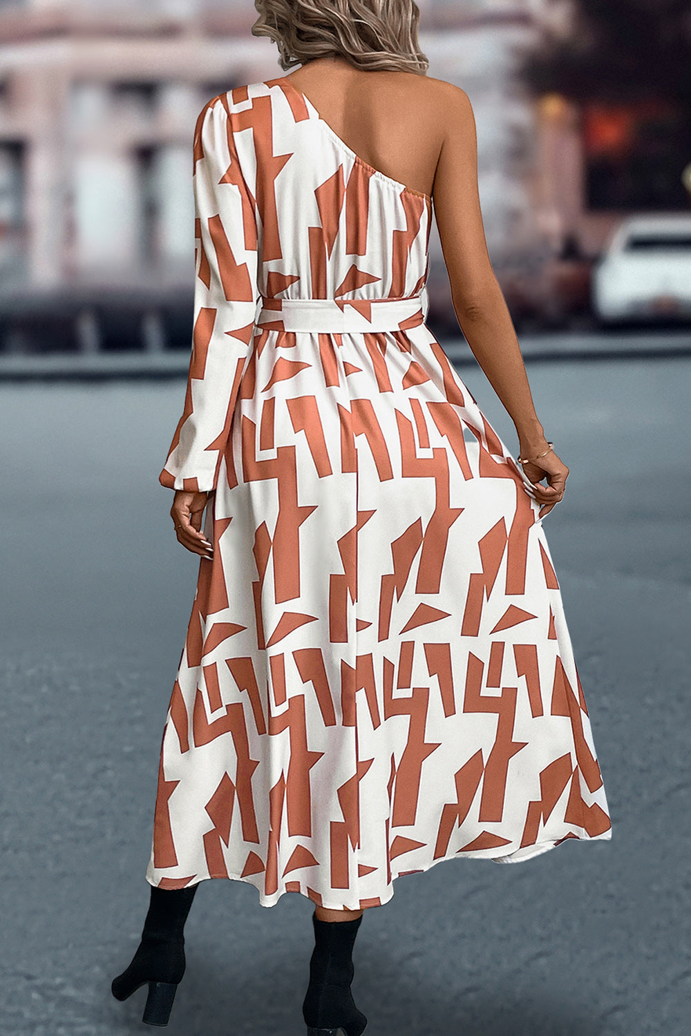 Geometric print asymmetric maxi dress with belt in cream and rust, one long sleeve, one sleeveless.