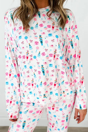 White long sleeve pajama set with a festive nutcracker, candy cane, and gift print.