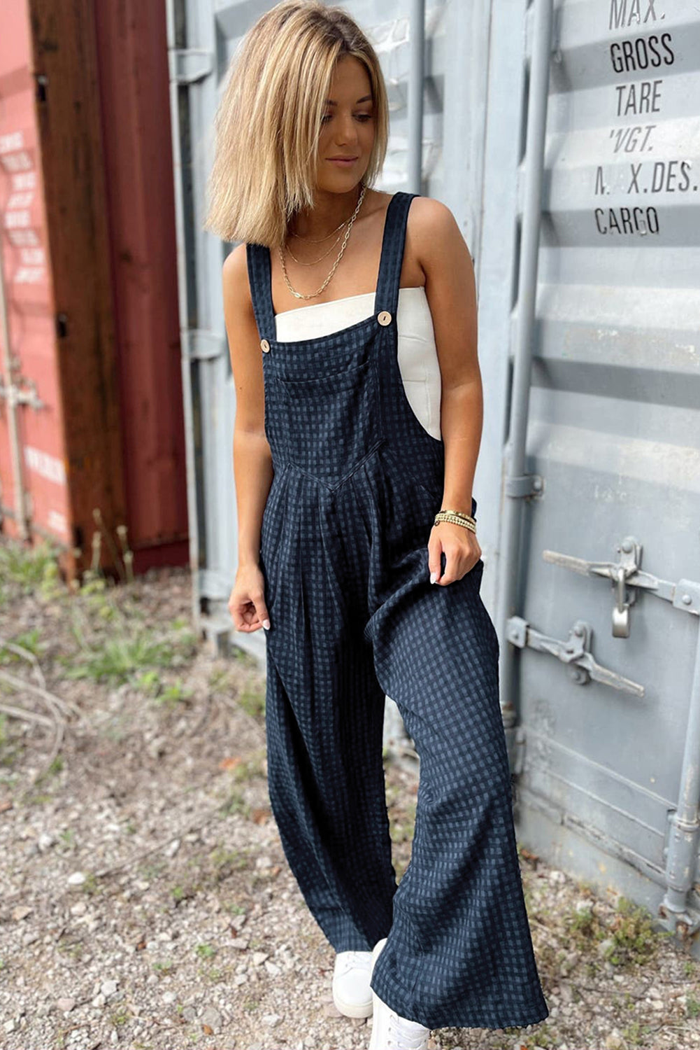 Dark blue textured wide-leg overalls with button detail and a V-neck bodice.