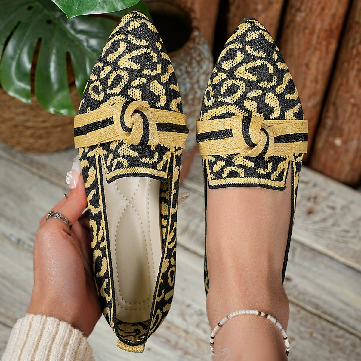 Knot detail point toe slip-ons in yellow and black abstract print with a comfortable knit design.