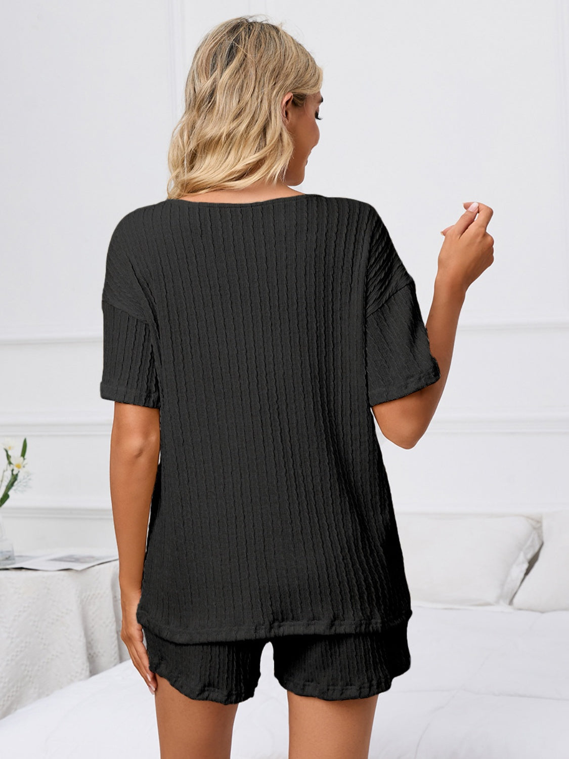 Black ribbed knit pajama set with short sleeves and shorts.