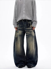 Men's vintage wash wide leg jeans with distressed detailing and a belted waist.