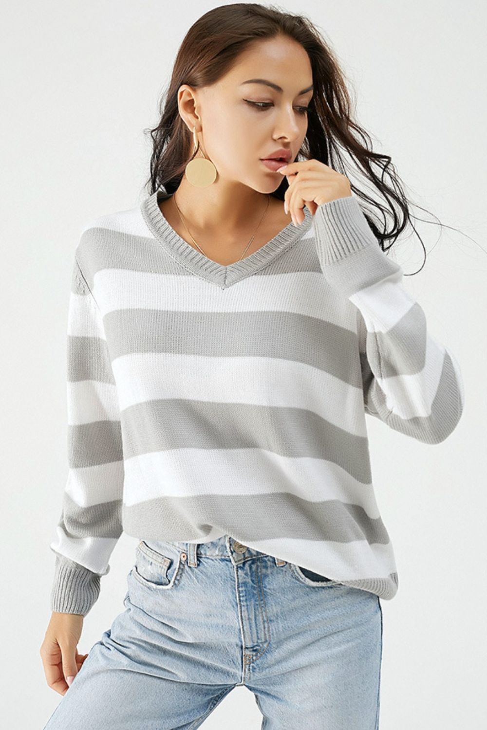 Gray and white striped V-neck relaxed knit sweater with ribbed cuffs and hem