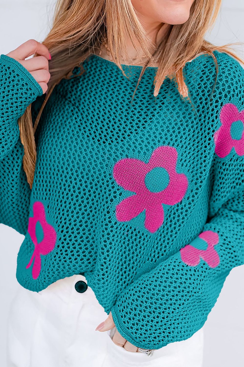 Openwork sweater in teal with pink floral intarsia pattern and crew neck.