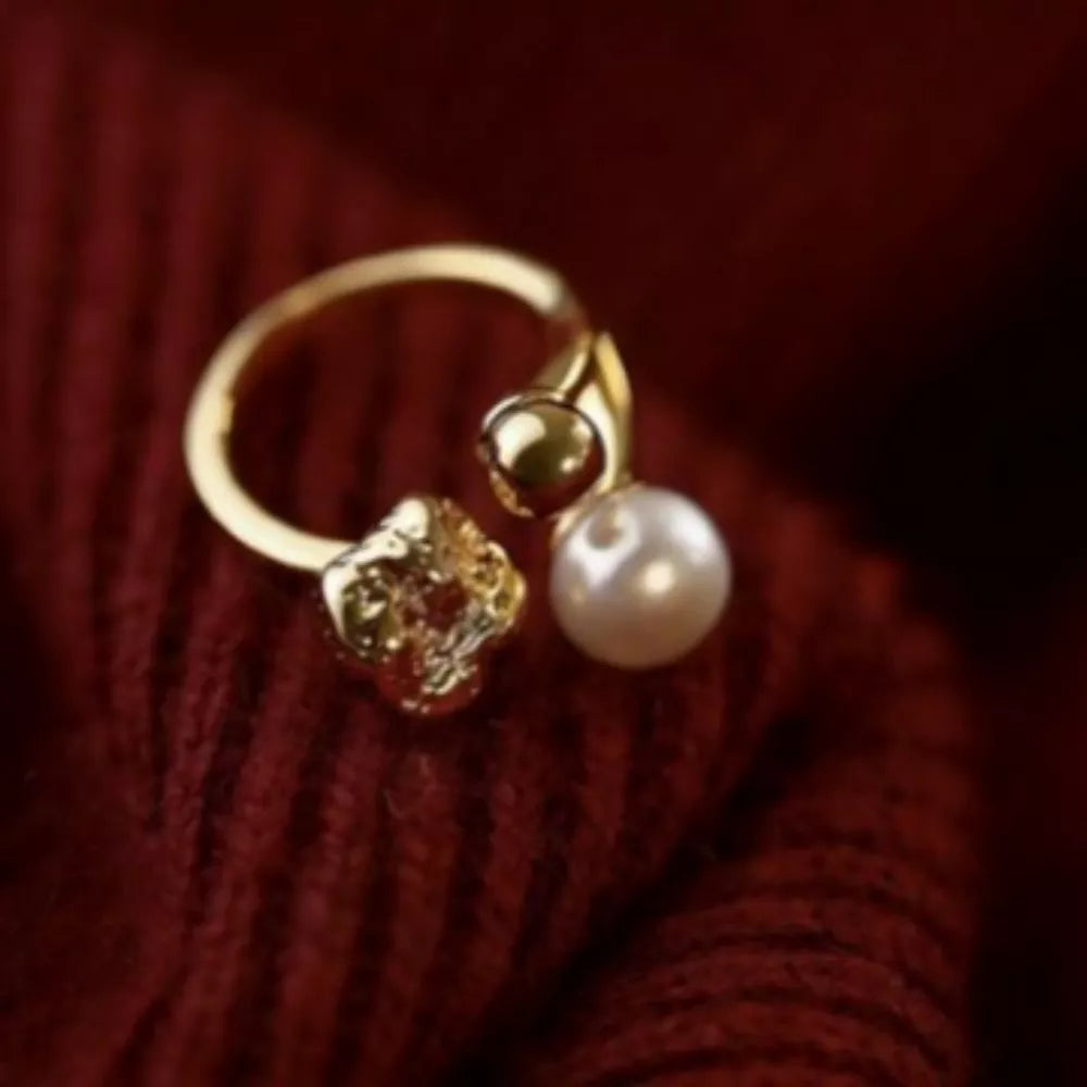 Gold open ring with pearl and textured gold detail.