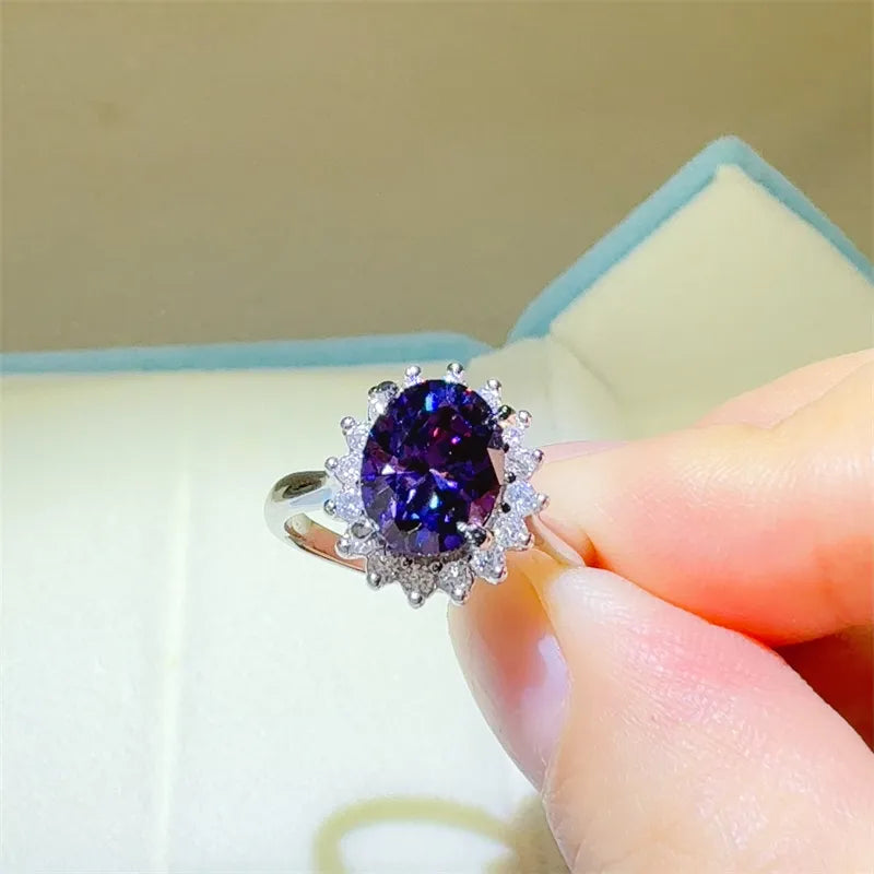 Silver ring with oval amethyst and sunburst moissanite halo.