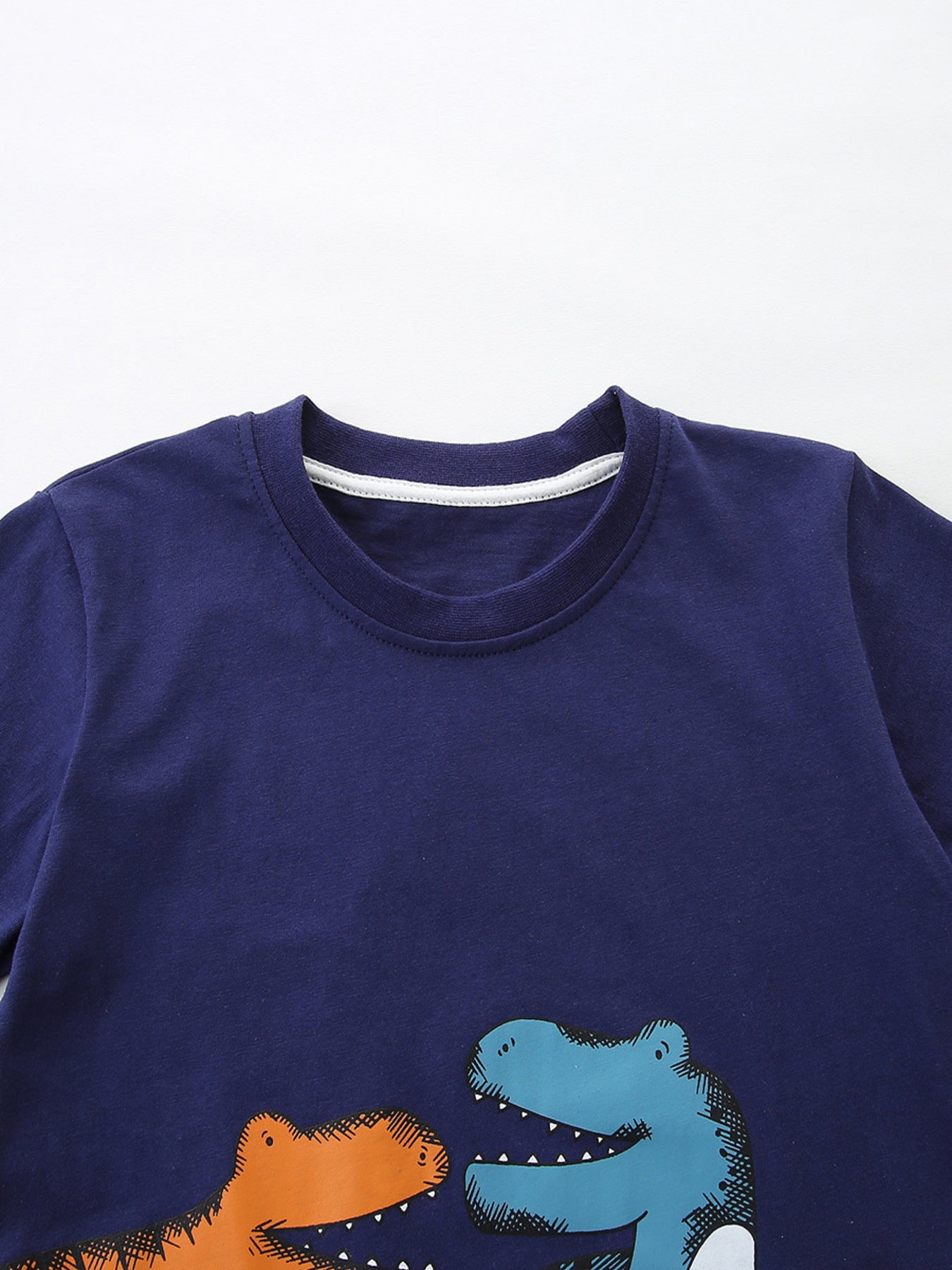 Navy cotton baby tee with playful orange and blue dinosaur graphic.