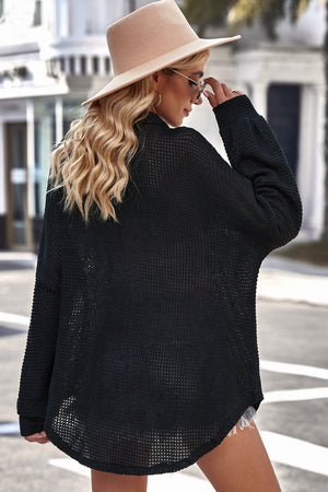 Black waffle-knit oversized shirt jacket with button-down front and curved hem.