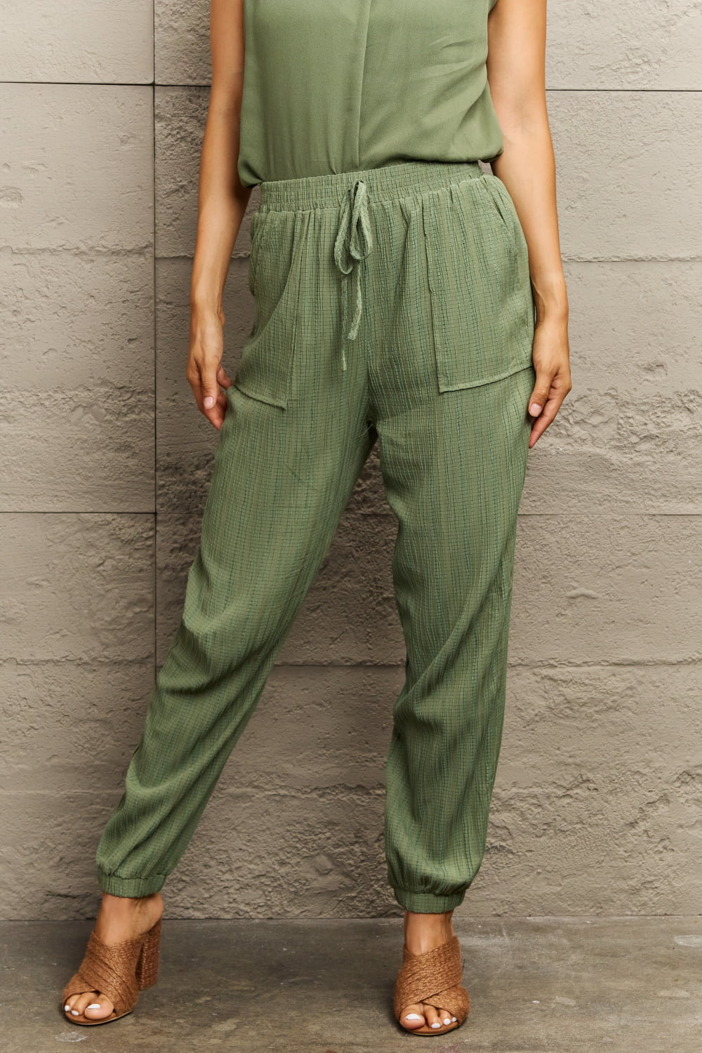 Matcha green textured gauze drawstring jogger trousers with elastic cuffs and pockets.