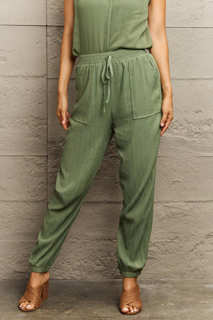 Matcha green textured gauze drawstring jogger trousers with elastic cuffs and pockets.