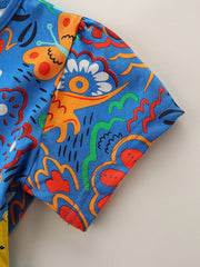 Toddler blue cotton dress with whimsical animal and floral print.