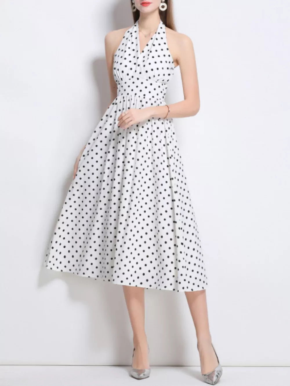 White polka dot halter midi dress with a cinched waist and full skirt.
