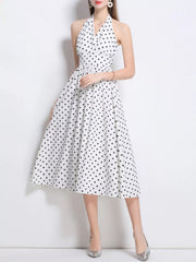 White polka dot halter midi dress with a cinched waist and full skirt.